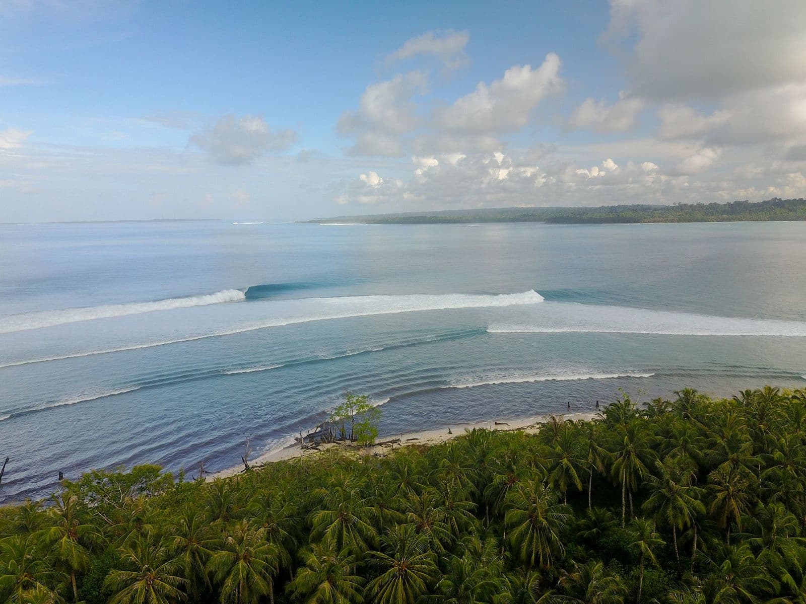 Lance’s Left from the air, two clean lines peeling down the reef past the palms